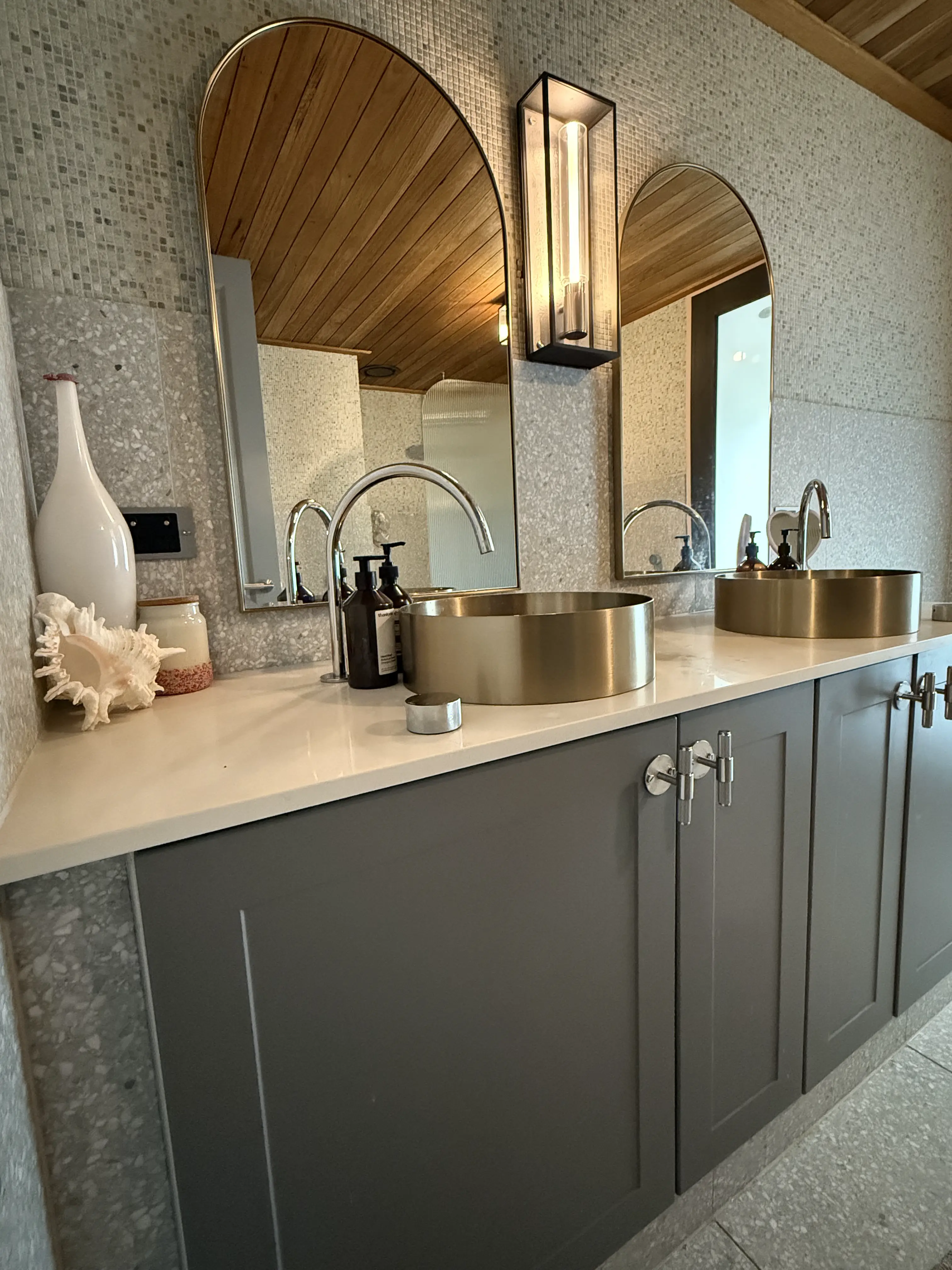 Custom vanity with arched mirrors and brass basins