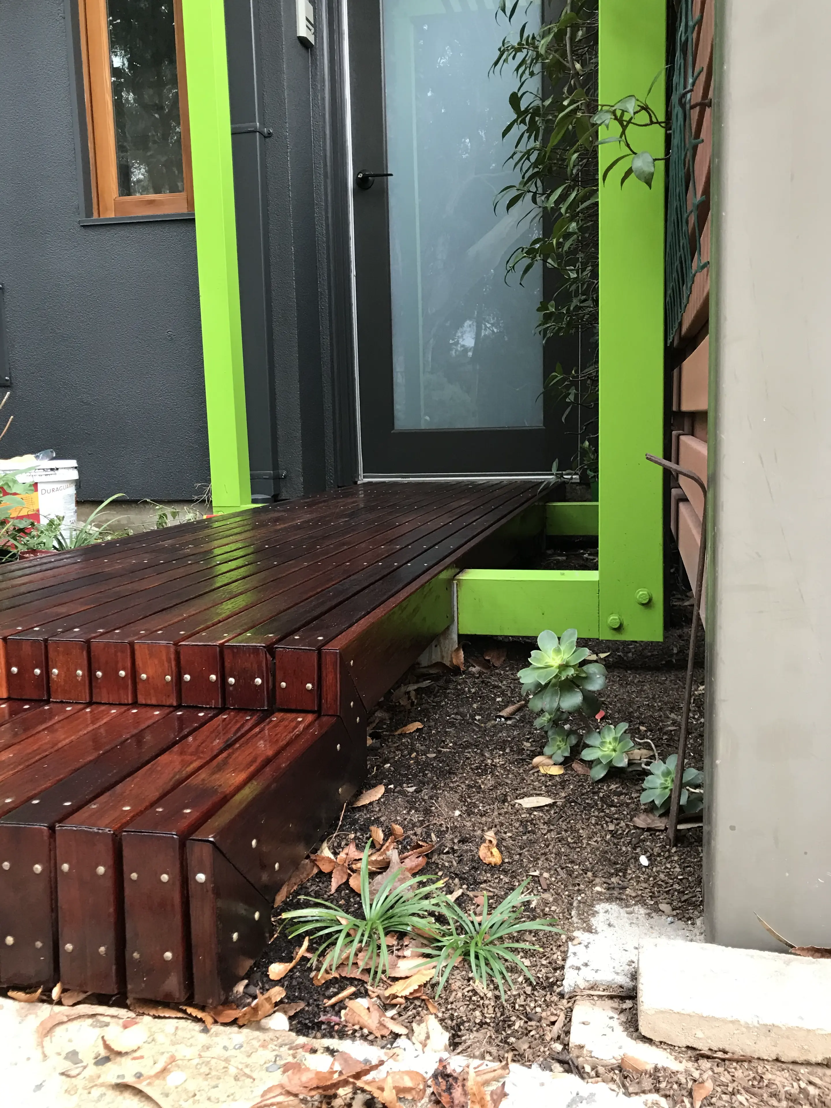 Boardwalk-style dark timber entry with lime green frame